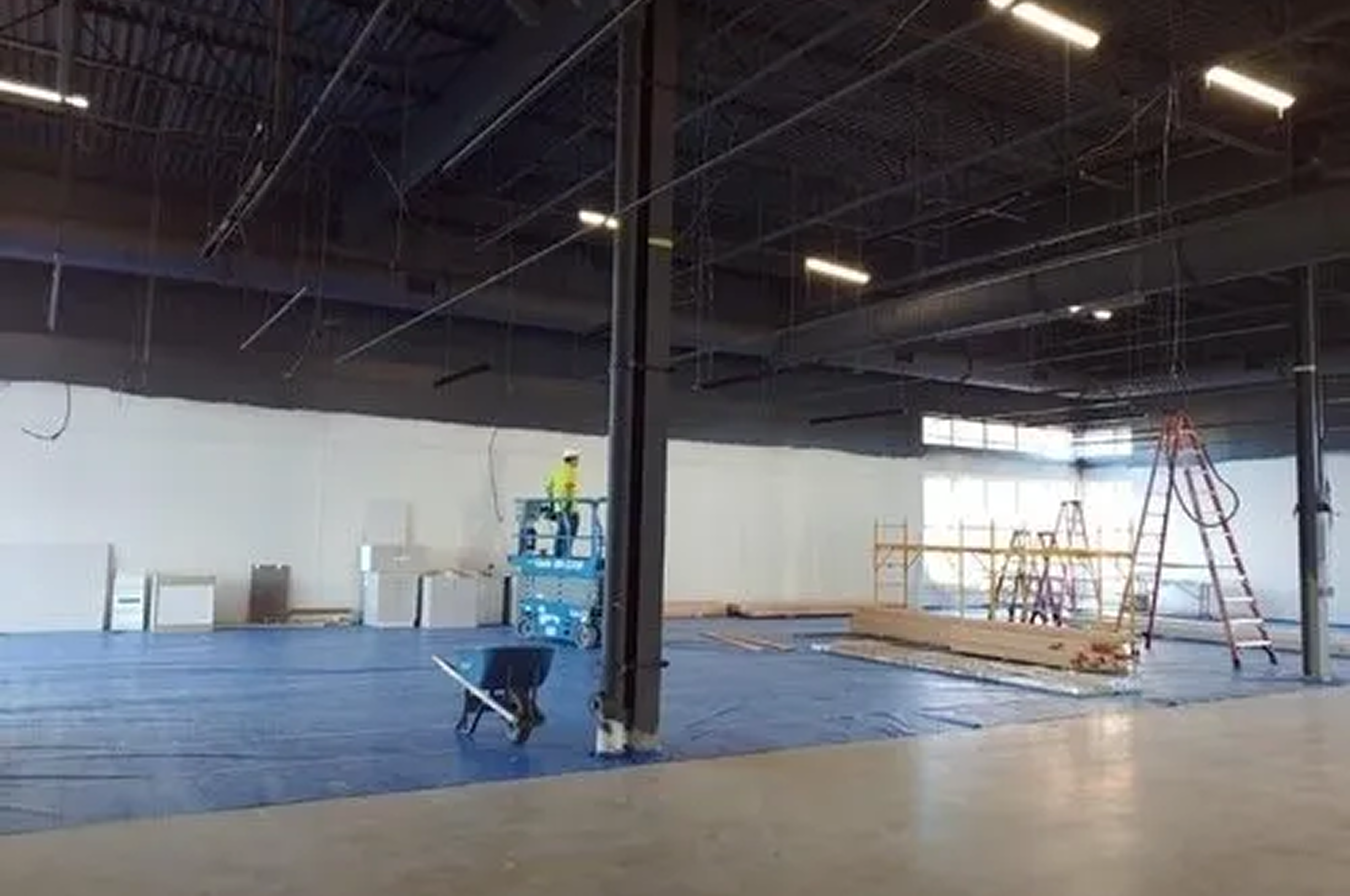 Empty warehouse space with blue tarp flooring